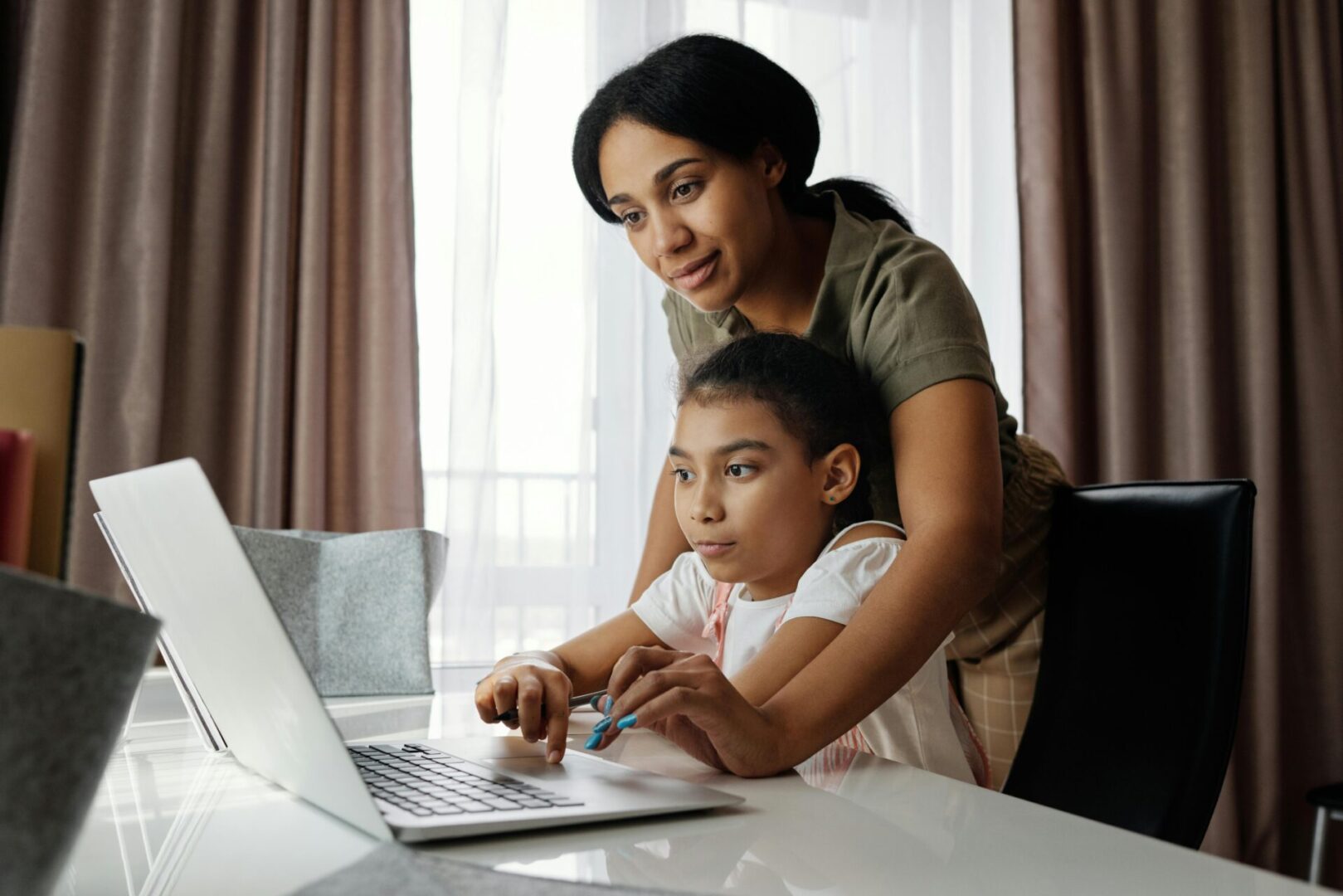 A woman and child using a laptop computer.